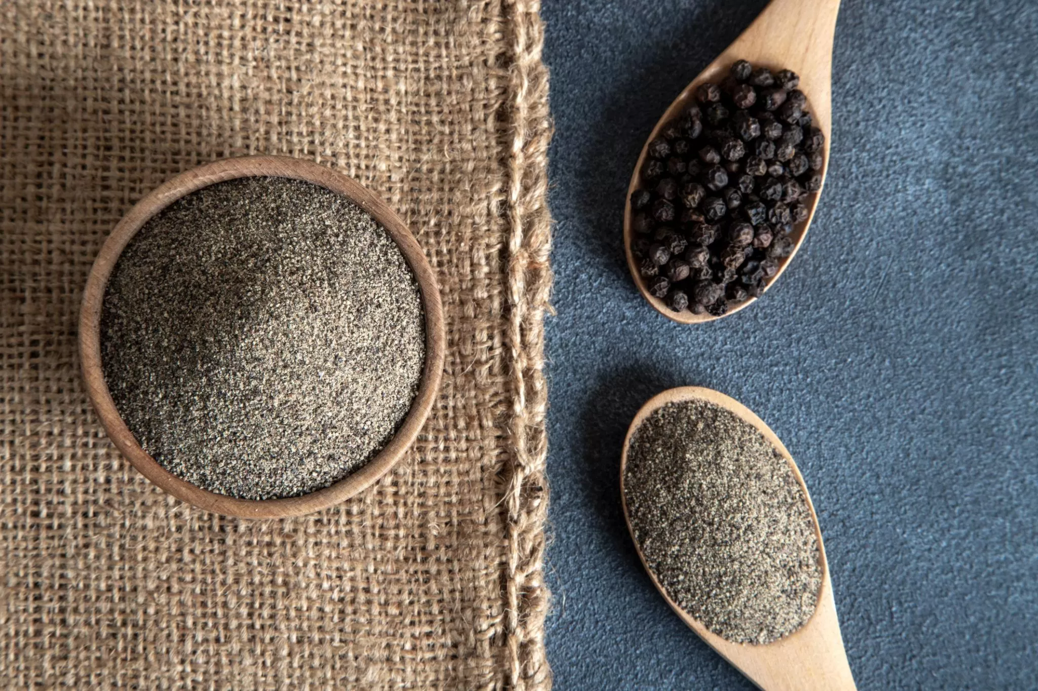 Ground black pepper powder close-up with natural black pepper seeds